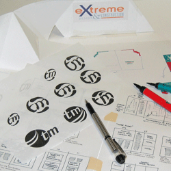 The concept stage of graphic design, showing marker sketches of a logo design on the desk, beside page layouts and a 3D mockup.
