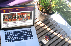 Mockup of "The Atholl Arms" Website on MacBook Pro and iPhone on a café table