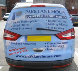 Rear view of vehicle wrap graphics on a silver Ford Galaxy. This view shows a blue clouds and sky theme with text and logo about a business support service in Glasgow.